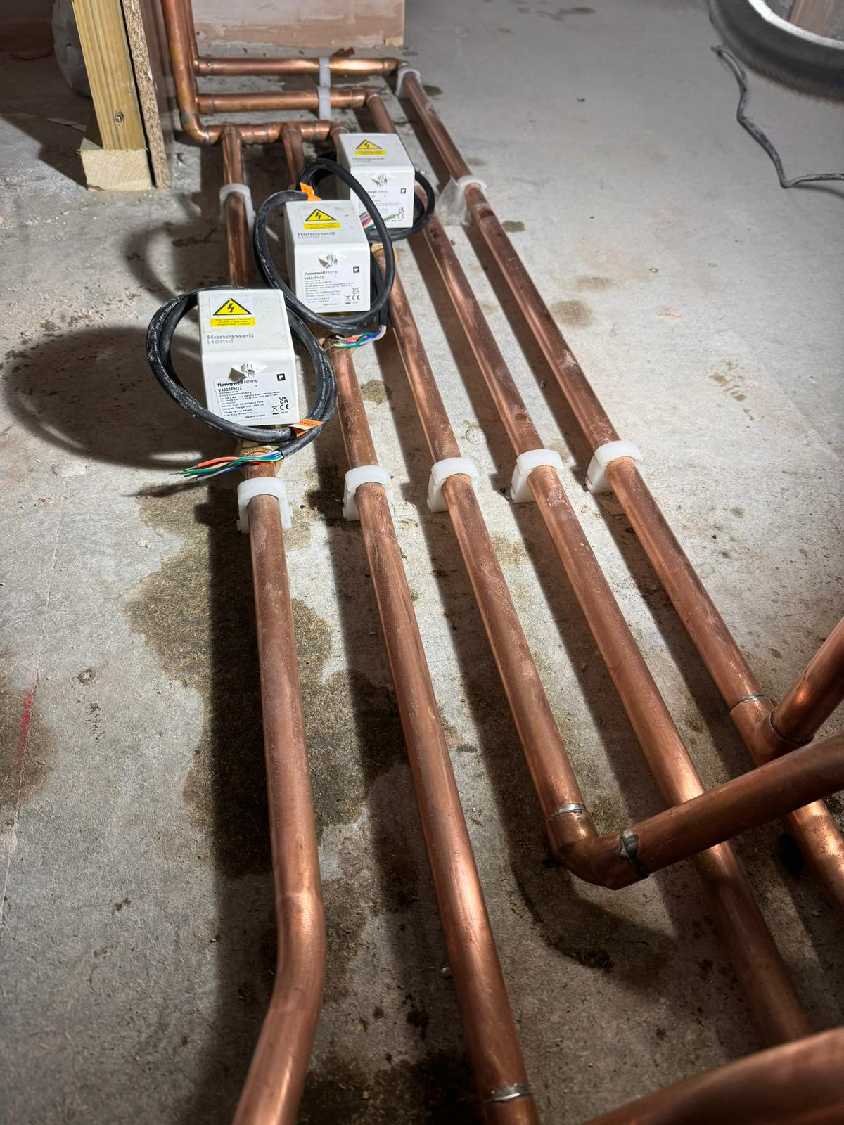 New copper central-heating pipework with Honeywell Home motorised zone valves during a boiler install