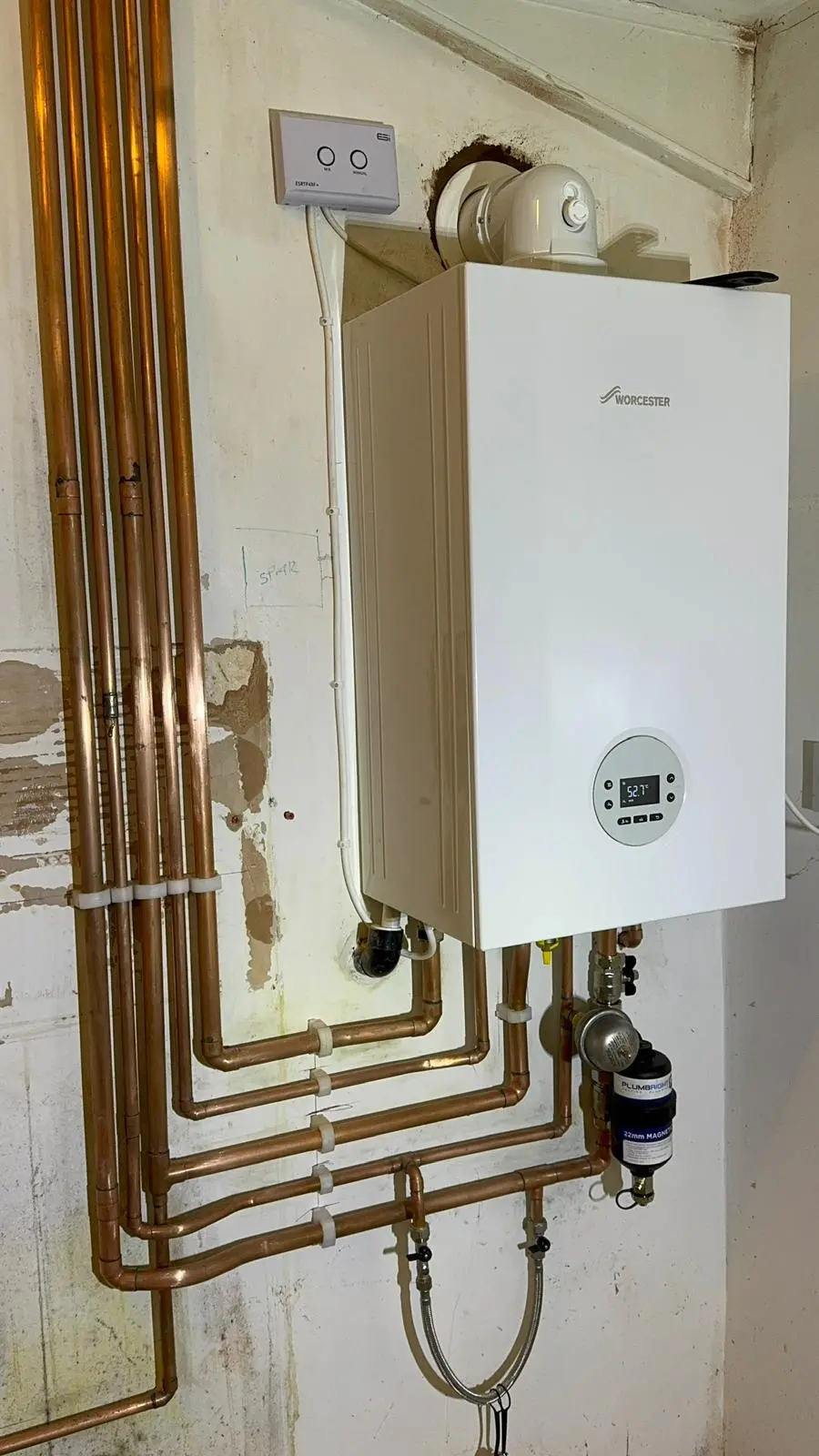 Close-up of a newly fitted Worcester Bosch boiler with clipped copper pipework below